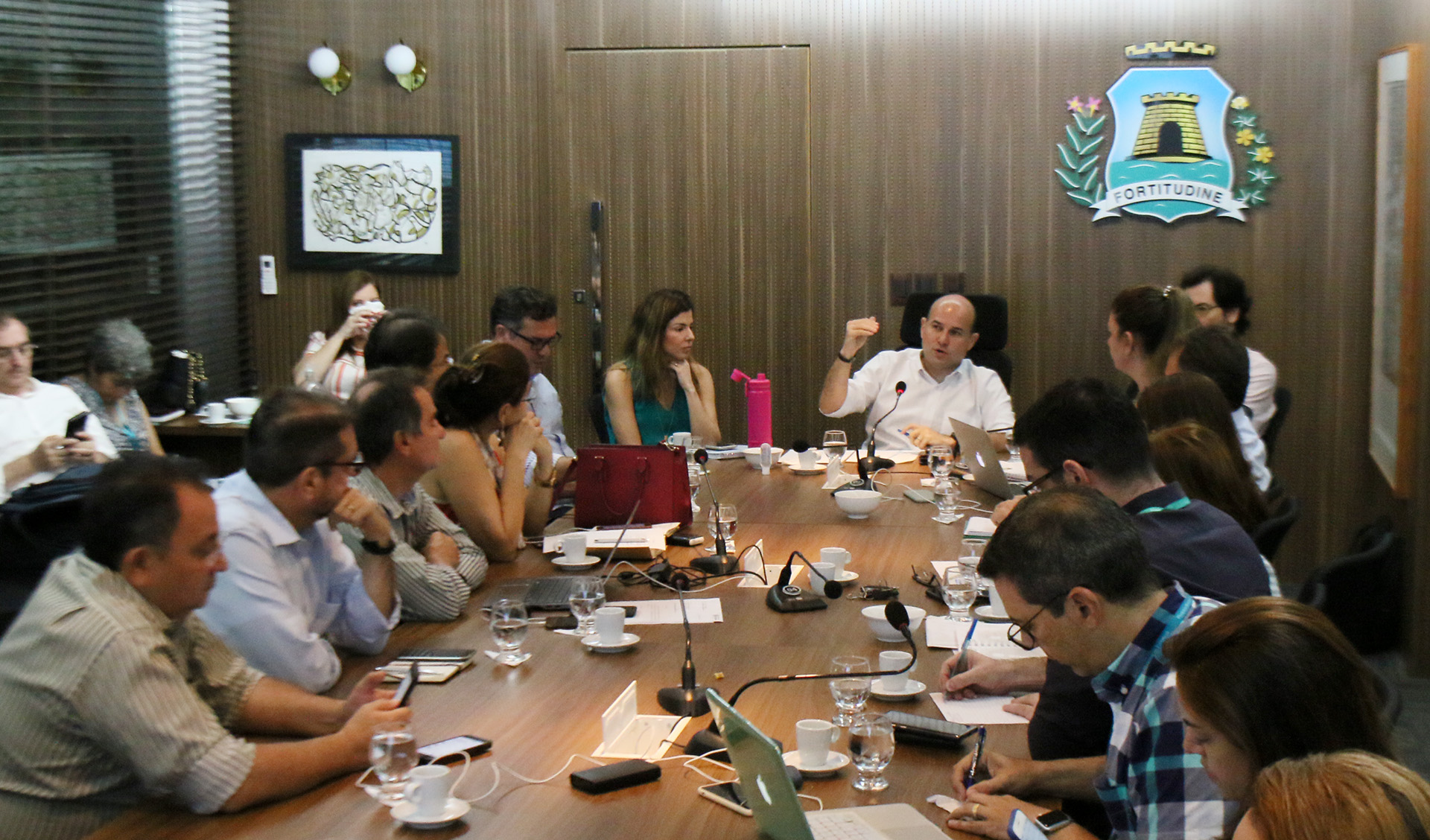 prefeito e pessoas sentados conversando ao redor de mesa